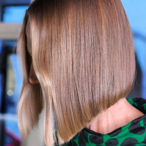 side portrait of woman with short mushroom blonde hair with light money piece