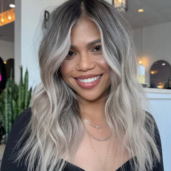 Long, tousled, silver blonde hair with dark roots.