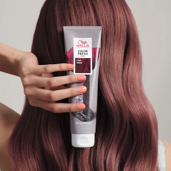 Model with rose brown hair holds up Color Fresh Mask in Rose Blaze.