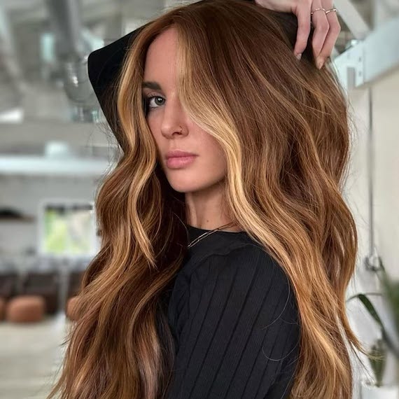 Model with chestnut brown hair featuring bright blonde face-framing highlights.