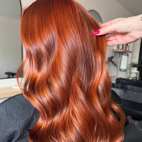 Vibrant cinnamon red hair with glossy finish.