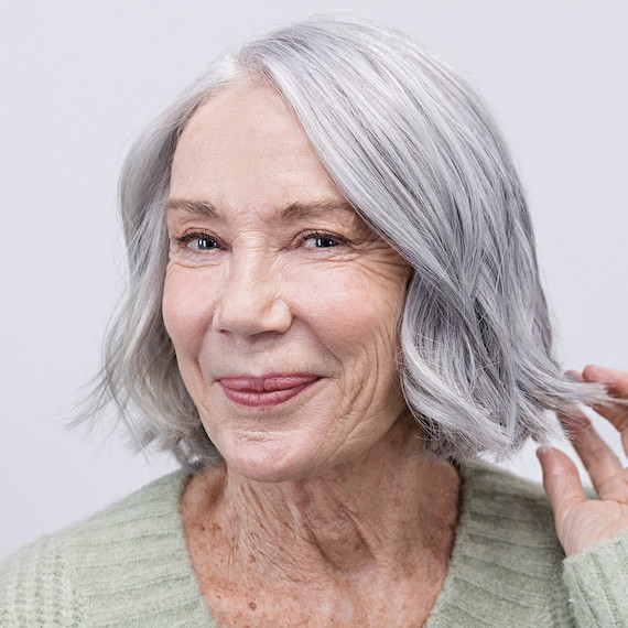 Model with shoulder-length bob showing off the results of her Wella True Grey service.