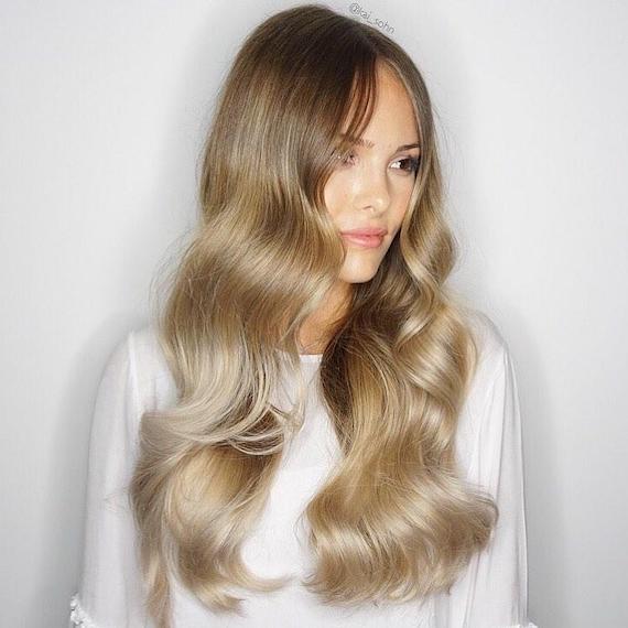 Photo of woman with very long, loosely curled hair and blonde foilyage, created using Wella Professionals.