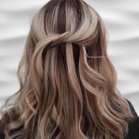 Back of woman’s head with frosted brown hair in a half-up knot, created using Wella Professionals.