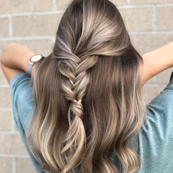 Back of woman’s head with frosted blonde hair in a braid, created using Wella Professionals.