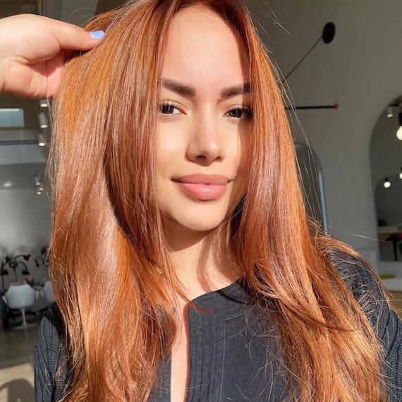 Headshot of a person with long ginger brown hair and brown eyes