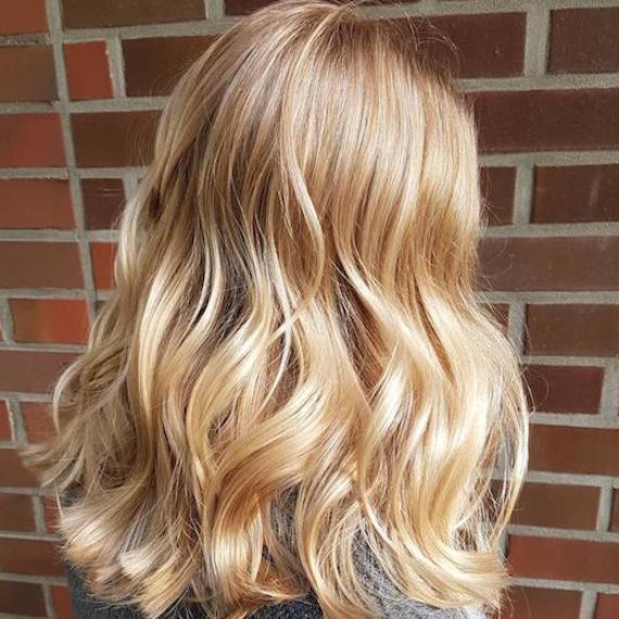 Side profile of woman with shoulder-length, light golden blonde hair, created using Wella Professionals. 