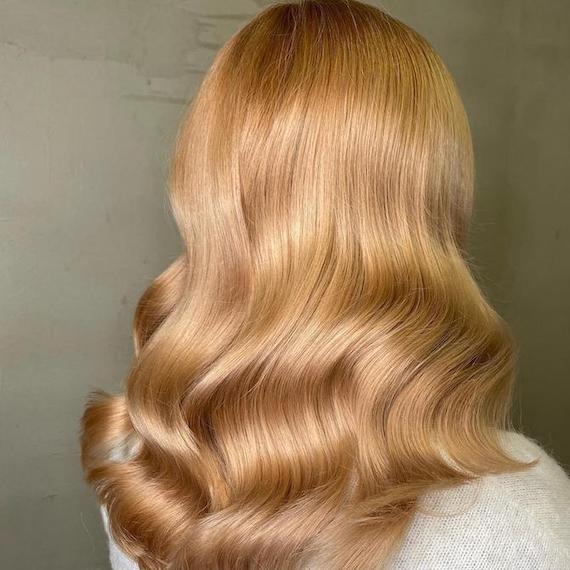 Back of woman’s head with long, golden copper blonde hair, created using Wella Professionals.