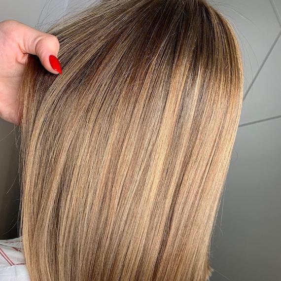 Photo of the back of a woman’s head with golden highlights, created using Wella Professionals.
