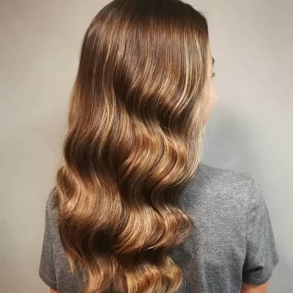 Photo of the back of a woman’s head with golden brown babylights, created using Wella Professionals.