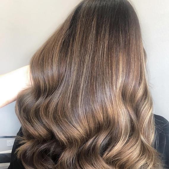 Photo of the back of a woman’s head with subtle golden brown balayage, created using Wella Professionals.
