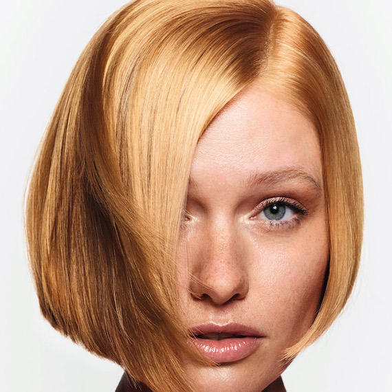 Close-up of model with chin-length, apricot blonde bob.