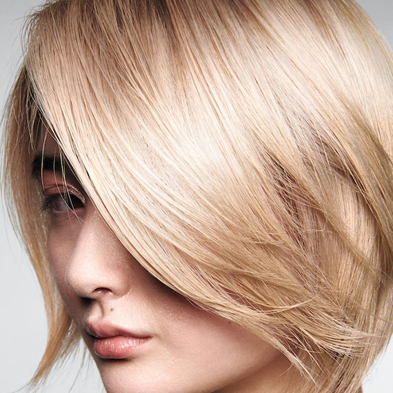 Close-up of model with ultra-shiny, butter blonde bob haircut.