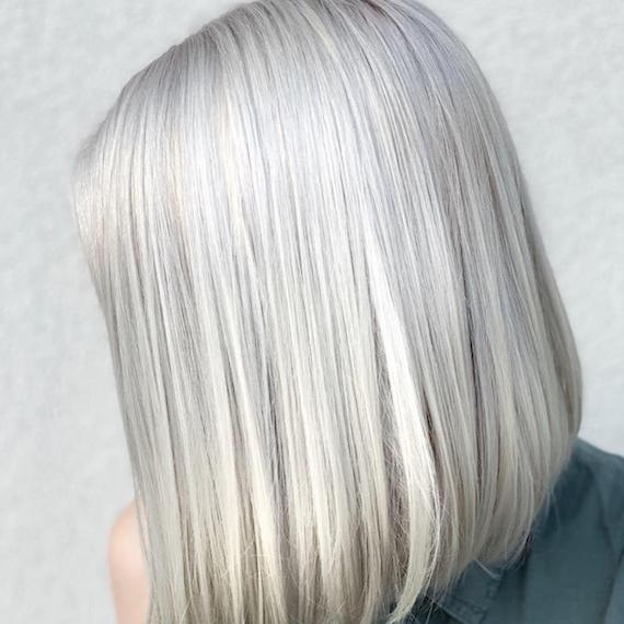 Side profile of woman with gray blonde bob, created using Wella Professionals.