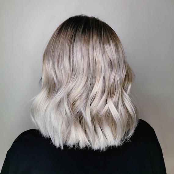 Back of woman’s head with short, wavy gray blonde bob, created using Wella Professionals.