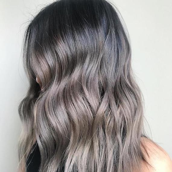 Side profile of woman with wavy, brown to gray ombre hair, created using Wella Profession-als.