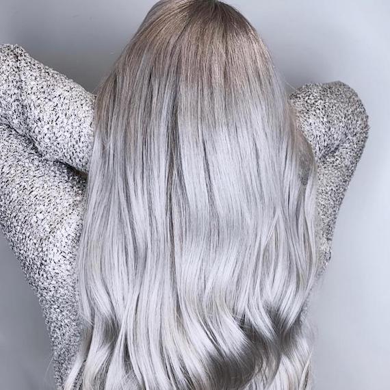 Back of woman’s head with long, wavy, silver-gray hair.