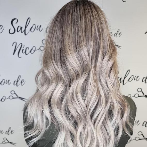 Back of woman’s head with long, wavy, silvery gray hair, created using Wella Professionals.