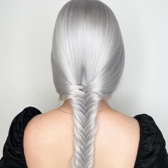 Back of woman’s head with long, silver, braided hair, created using Wella Professionals.