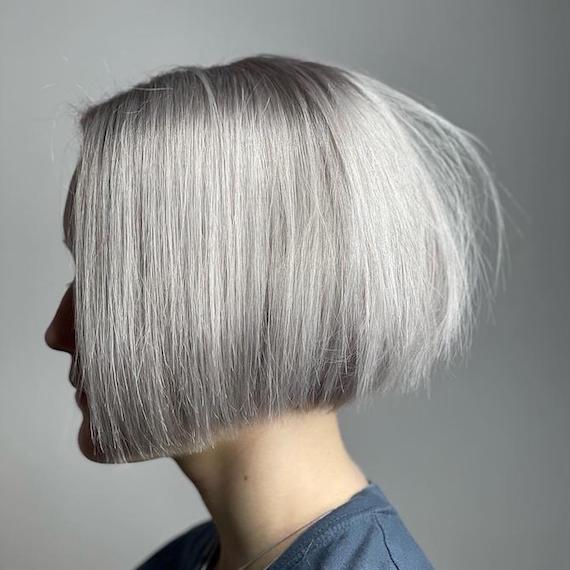 Side profile of woman with blunt gray bob hairstyle, created using Wella Professionals.