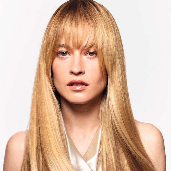 Model with long, straight, honey blonde hair and glass-like shine.