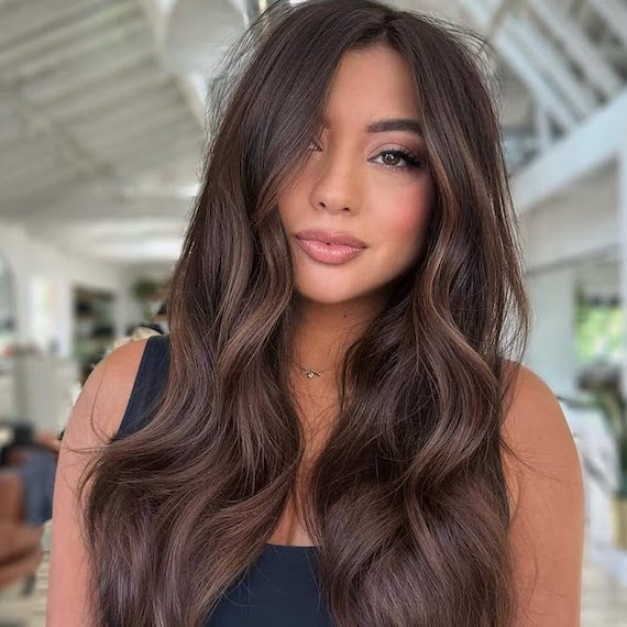 Model with long, mocha mousse brown hair styled in beachy waves.