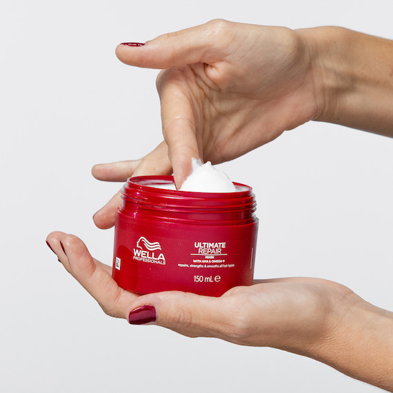 A hand reaches into a tub of ULTIMATE REPAIR Mask.