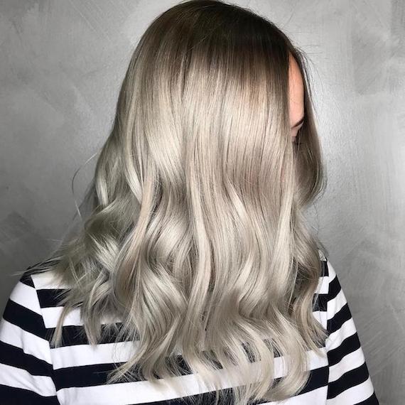 Side profile of woman with mid-length, wavy, silver hair, glossed using Wella Professionals