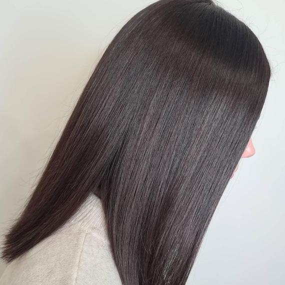 Side profile of woman with sleek, straight, black hair.