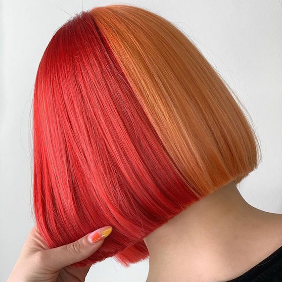 Back of woman’s head with half and half hair color in orange and red, created using Wella Professionals.