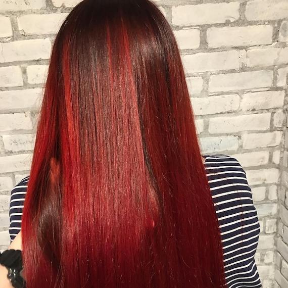 Back of woman’s head with long, straight, red and black hair, created using Wella Professionals.