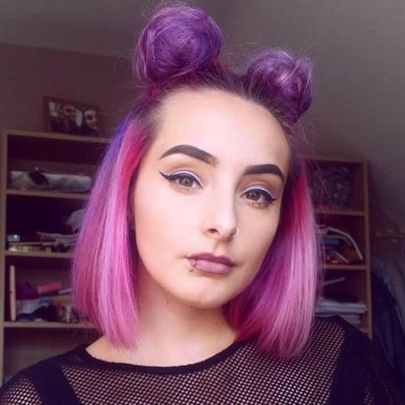 Woman with hot pink and purple space buns hairstyle, created using Wella Professionals.