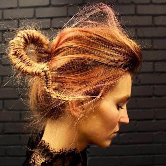 Side profile of woman with red hair teased into a tight fishtail braid, created using Wella Professionals. 