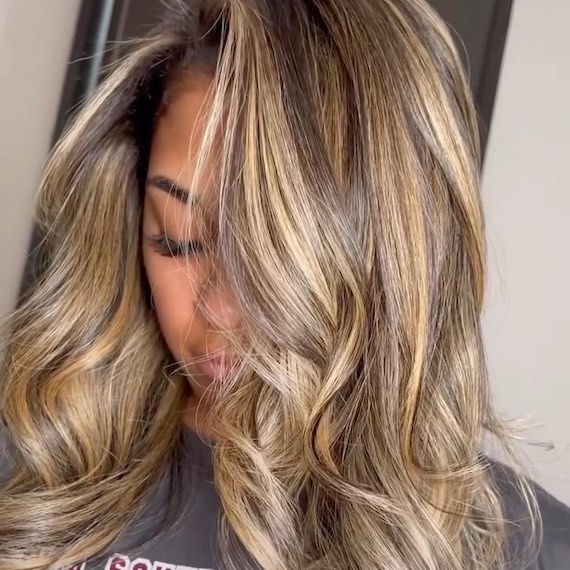 Headshot of a person looking down to show their blonde and brunette high contrast balayage hairstyle