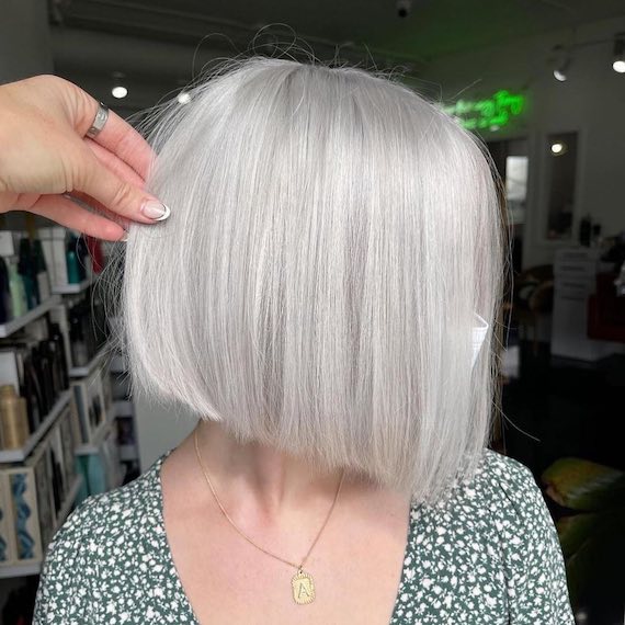 Person looks to the side revealing their newly styled silver blonde bob.