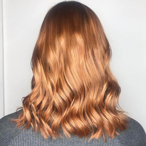 Photo of the back of a woman’s head showing red hair with copper highlights, created using Wella Professionals