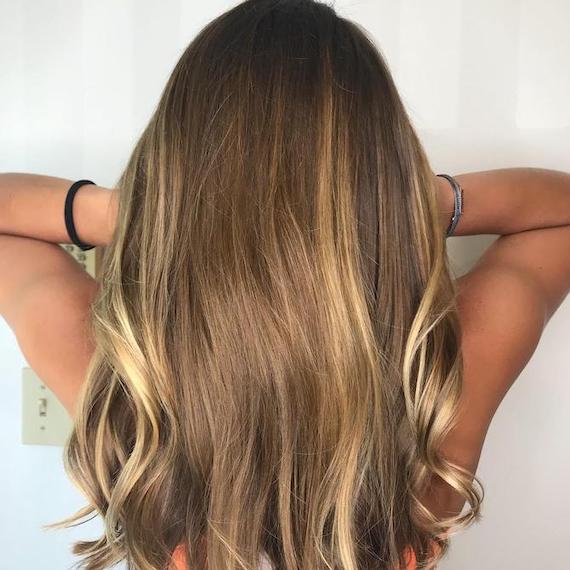 Photo of the back of a woman’s head showing brown hair with blonde highlights, created using Wella Professionals