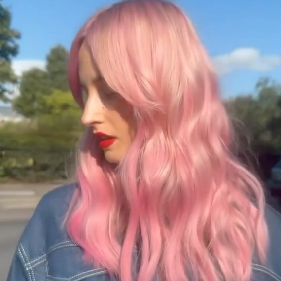 Side profile of model with pastel pink hair featuring hot pink tones through the ends.
