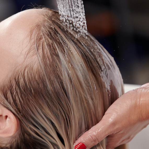 Close-up of model having their hair washed in a salon sink.