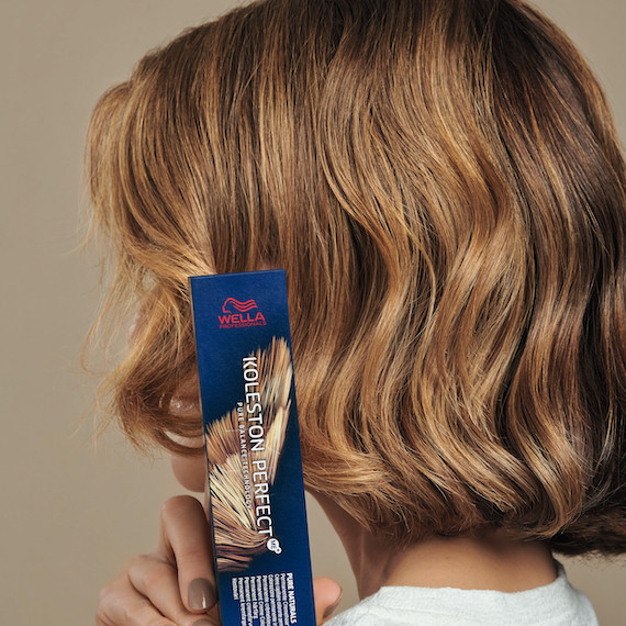 Back of model’s head with caramel bronde, short, wavy hair.