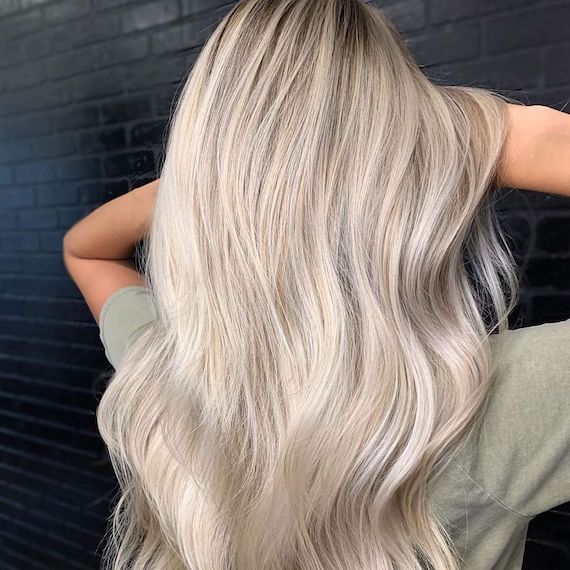 Back of model’s head with long, wavy, icy blonde hair.
