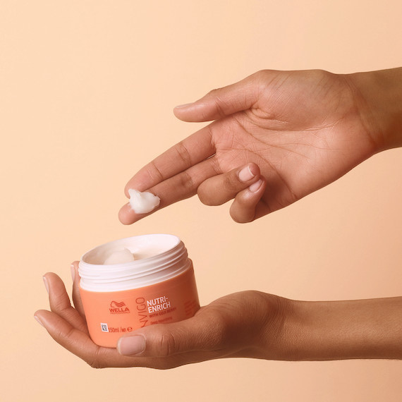 Hand holding the INVIGO Nutri-Enrich Deep Nourishing Hair Mask.