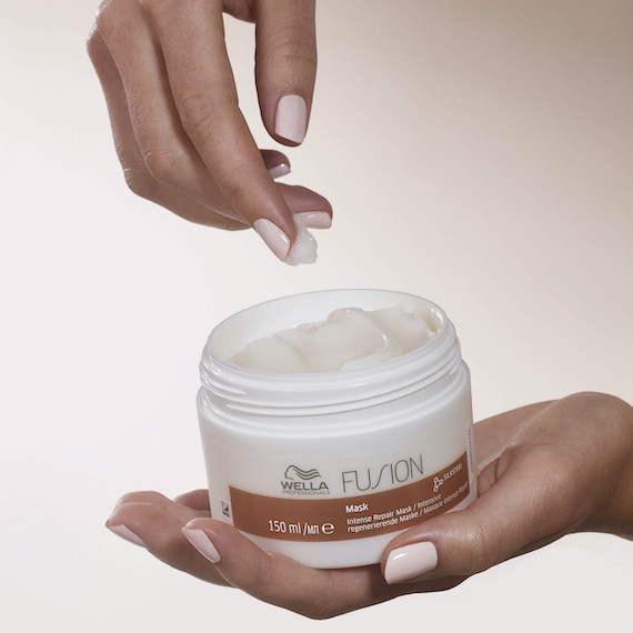 Hand reaches toward an open jar of Fusion Mask.