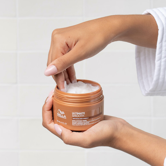 Model scoops out ULTIMATE SMOOTH Intense Mask from the jar.