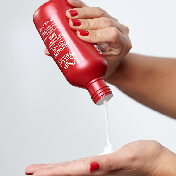 ULTIMATE REPAIR Shampoo is poured into model’s hand.