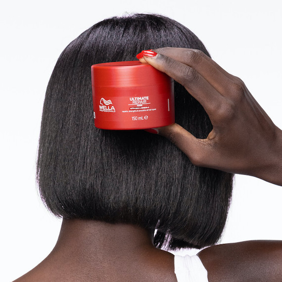 Model with short, black, straight hair holds up ULTIMATE REPAIR Mask.