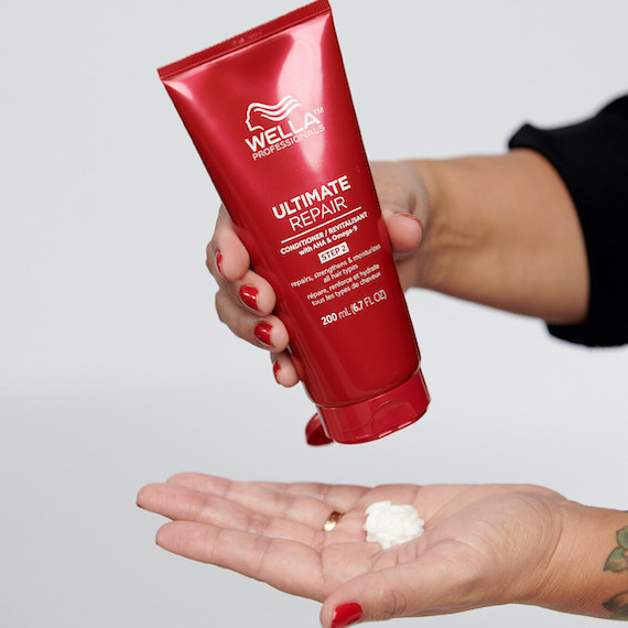 Ultimate Repair Conditioner is poured into hand. 
