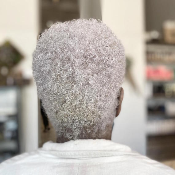 Back of woman’s head with short ice blonde curly hair, created using Wella Professionals.