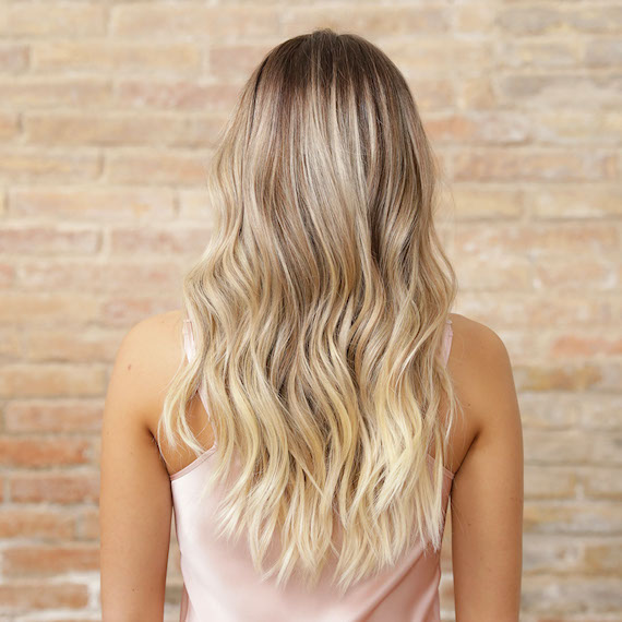 Back of head shows long, blonde hair that’s been colored using the Illuminage technique by Wella Professionals. 