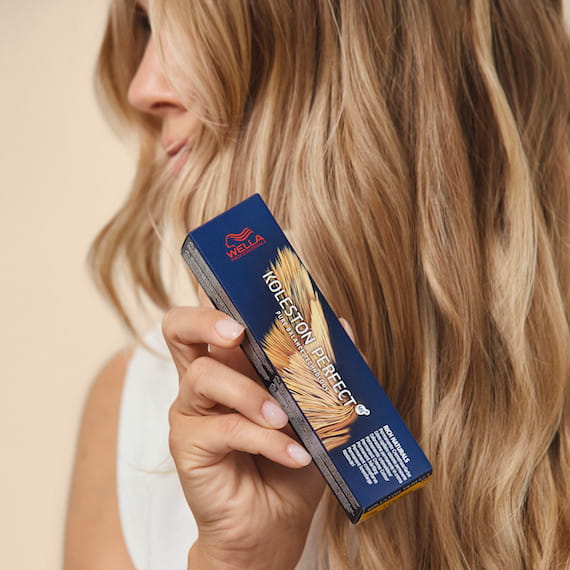 Close-up of beachy blonde hair as woman holds Koleston Perfect colour.